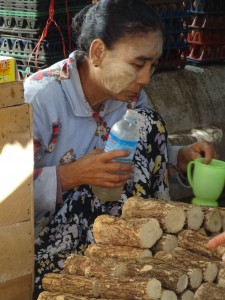 Market woman wearing and making Thanaka 